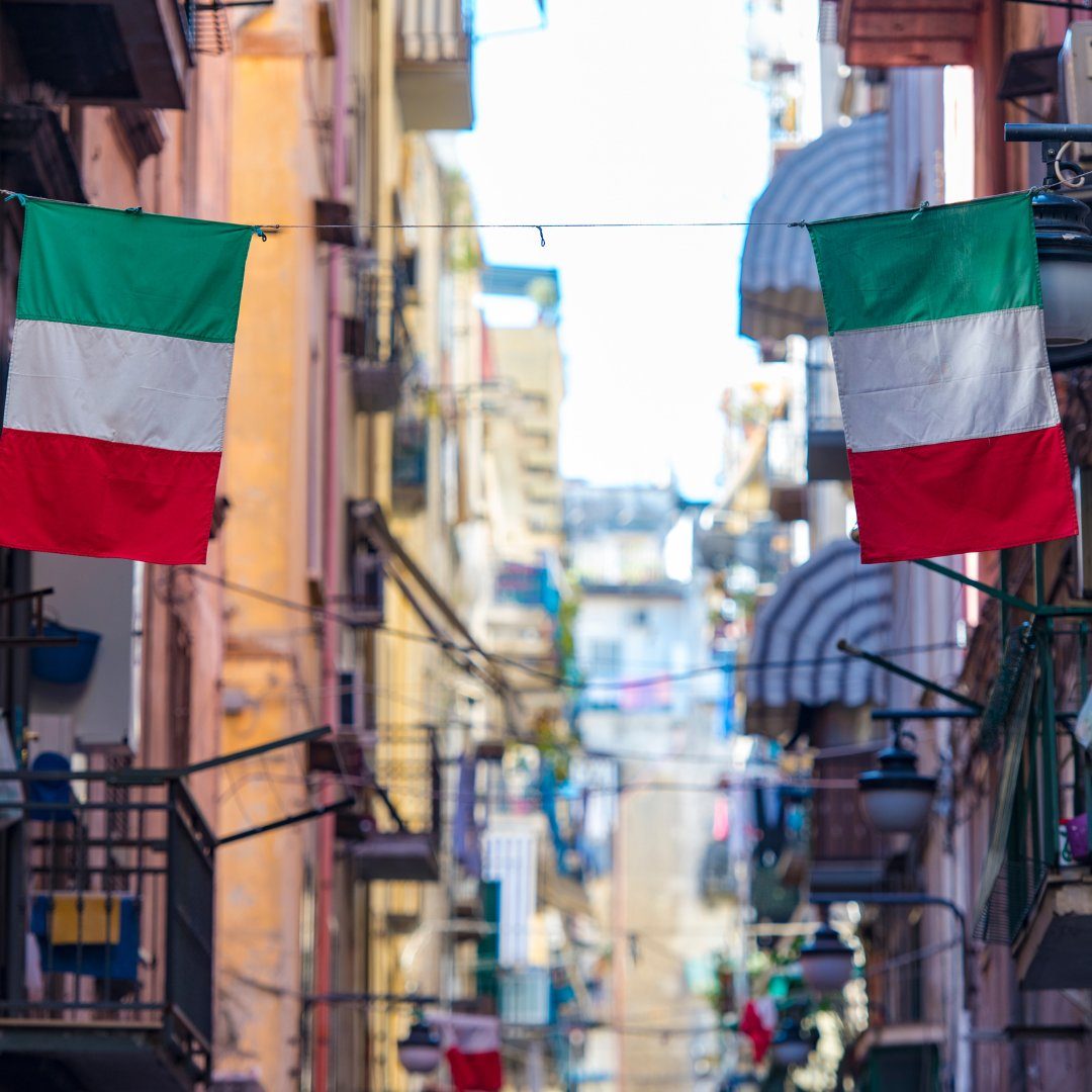 Bandiere italiane appese attraverso una stretta strada dei Quartieri Spagnoli di Napoli