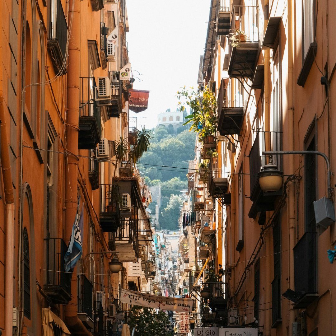 La stretta strada di Spaccanapoli nel centro storico di Napoli vista tra alti palazzi color ocra